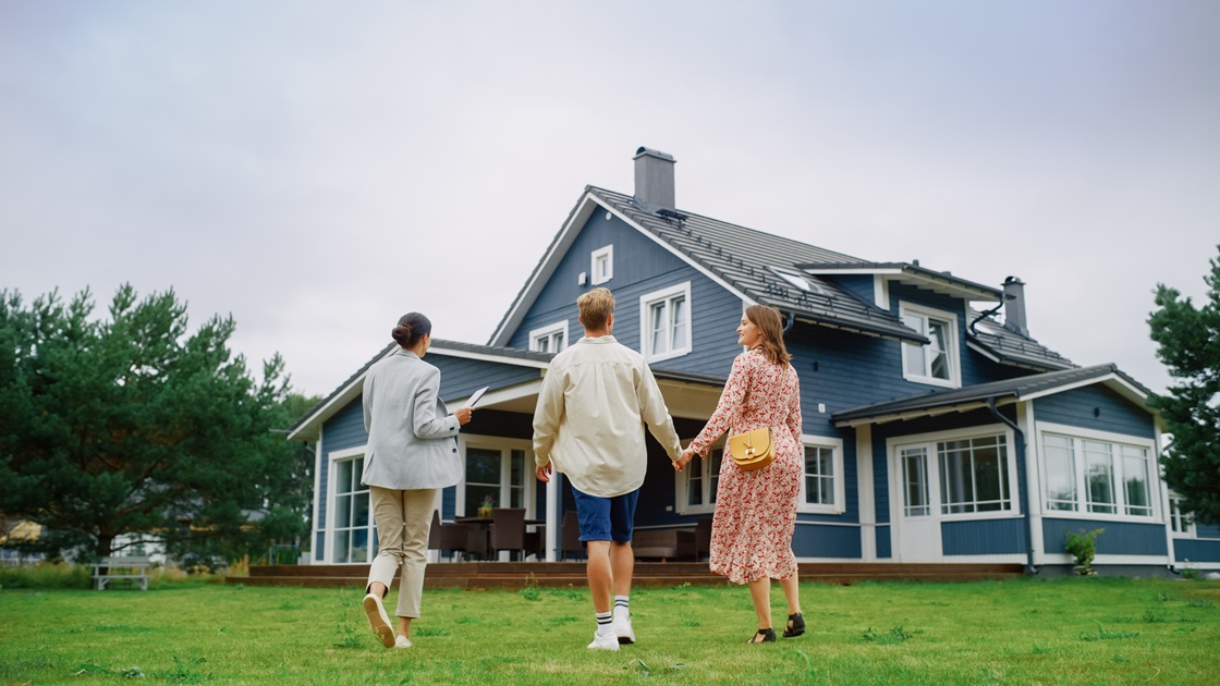 Real Estate Agent Showing a Beautiful Big House to a Young Successful Couple.